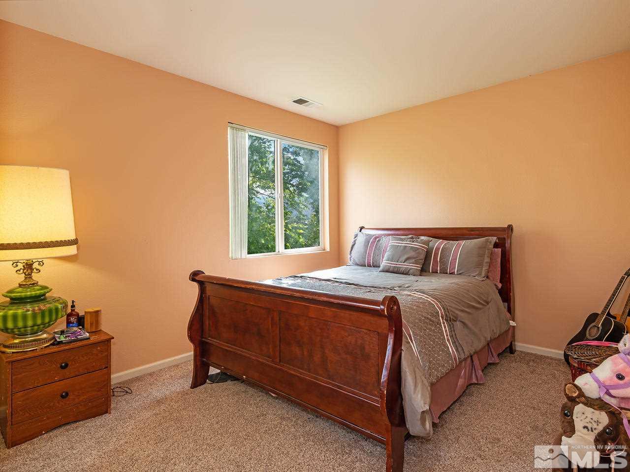 10675 Silver Cliff Way Reno, NV 89521 - Photo 13 of 16 a bed sitting in a bedroom next to a window