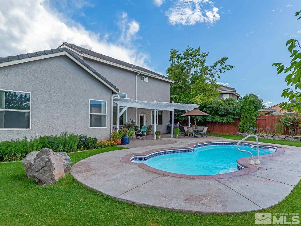 10675 Silver Cliff Way Reno, NV 89521 - Photo 4 of 16 a view of a house with a swimming pool and porch