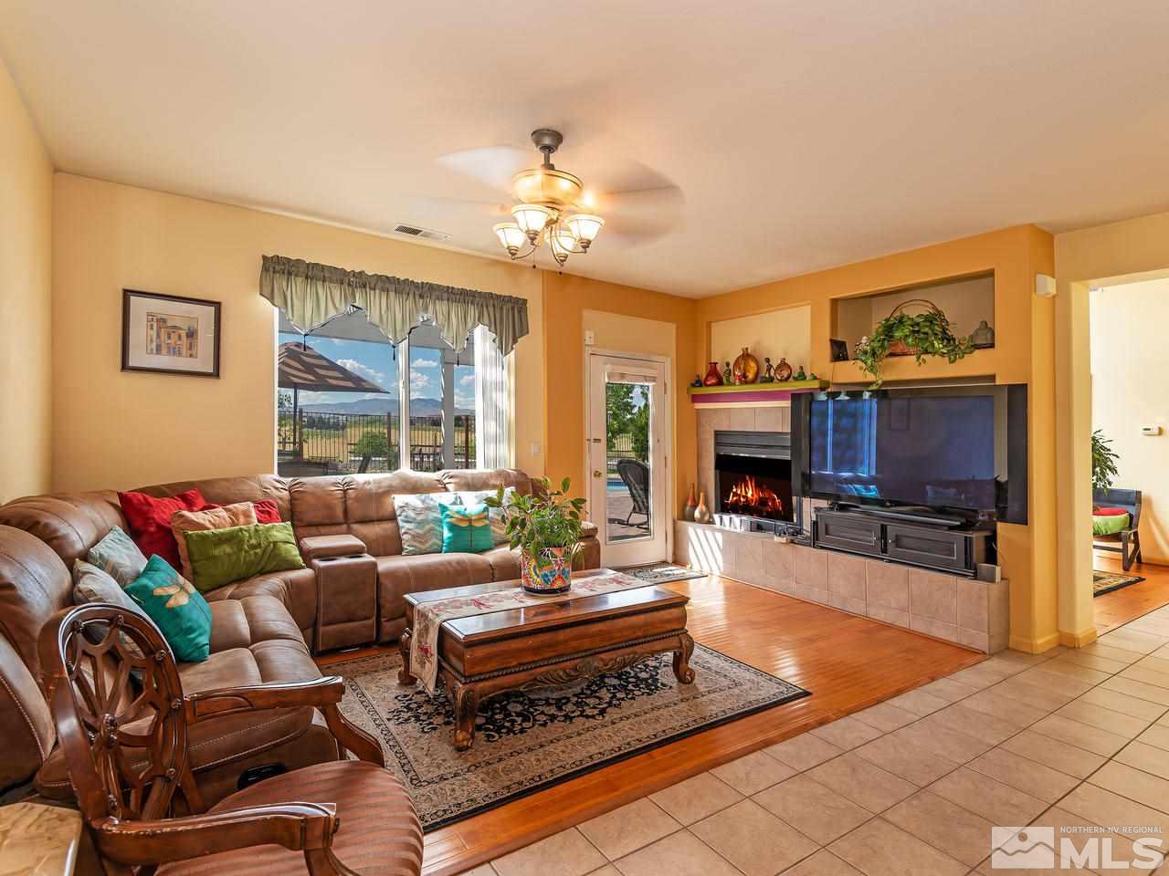 10675 Silver Cliff Way Reno, NV 89521 - Photo 6 of 16 a living room with furniture a fireplace and a flat screen tv