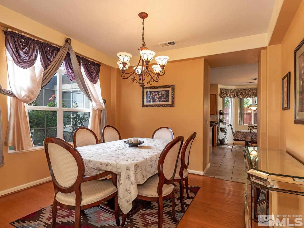 10675 Silver Cliff Way Reno, NV 89521 - Photo 9 of 16 a view of a dining room with furniture wooden floor and a chandelier