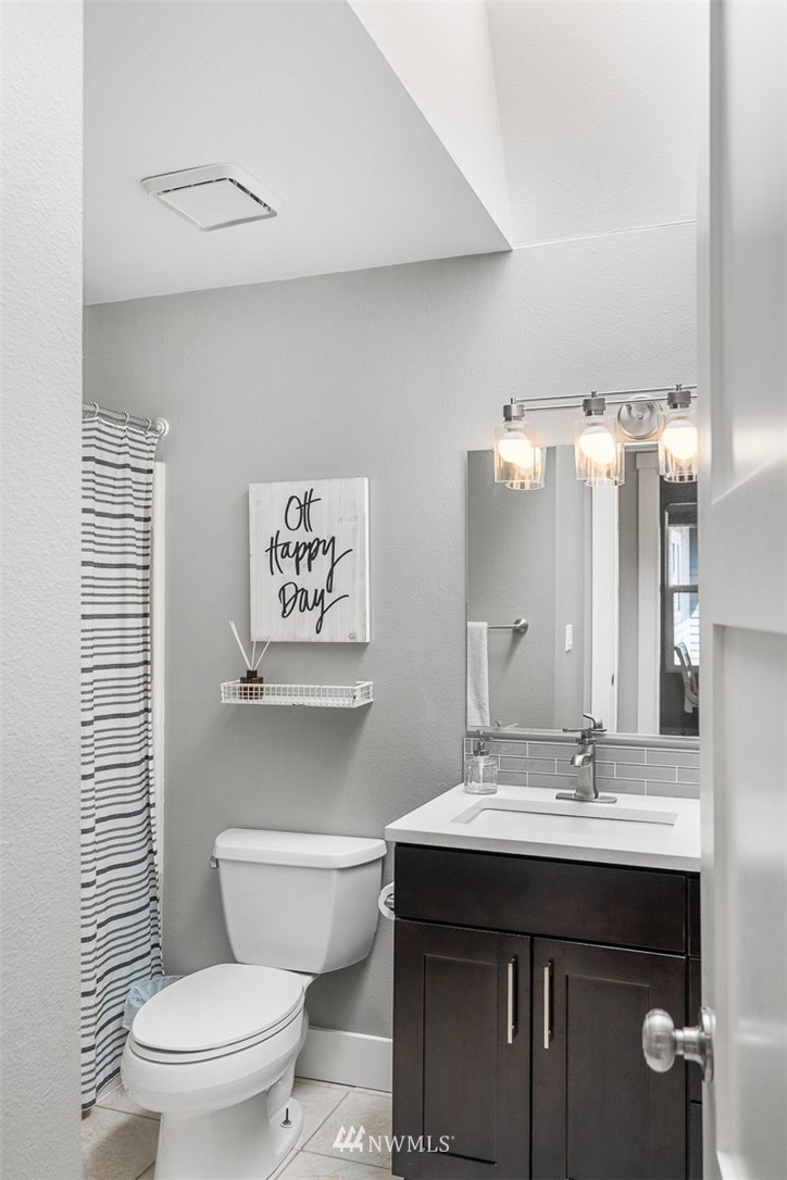 14011 Connelly Road Snohomish, WA 98296 - Photo 22 of 34 a bathroom with a sink a toilet a mirror and shower curtain