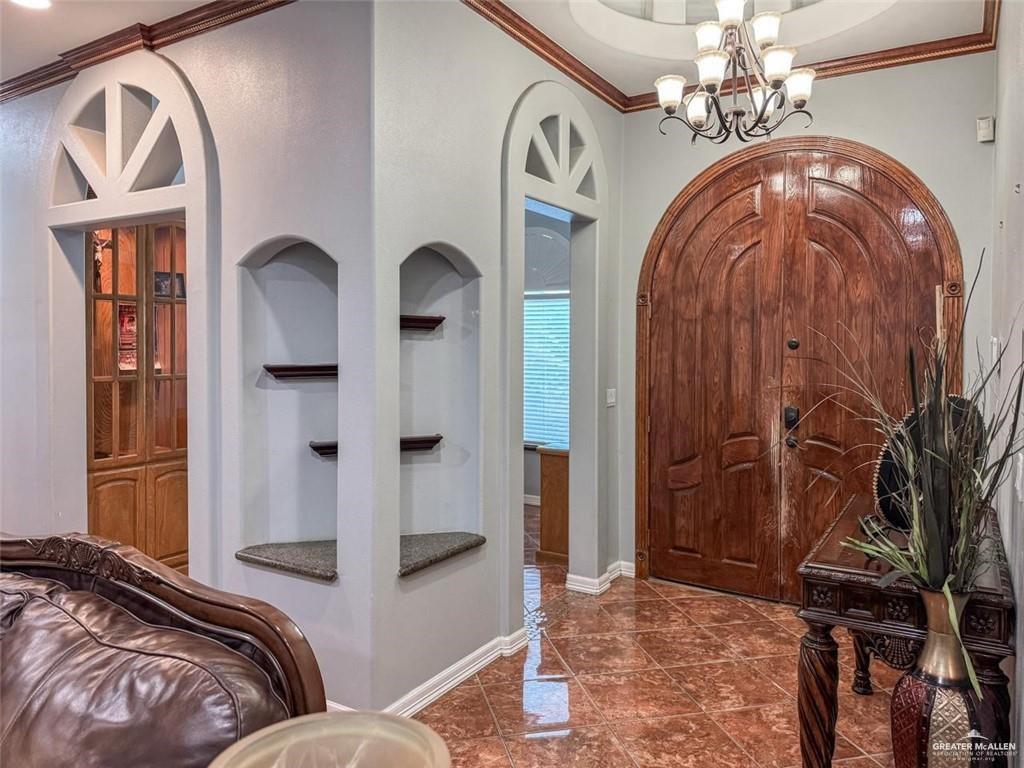 120 South Retama Lane Weslaco, TX 78596 - Photo 18 of 19 a spacious bedroom with a bed and a chandelier