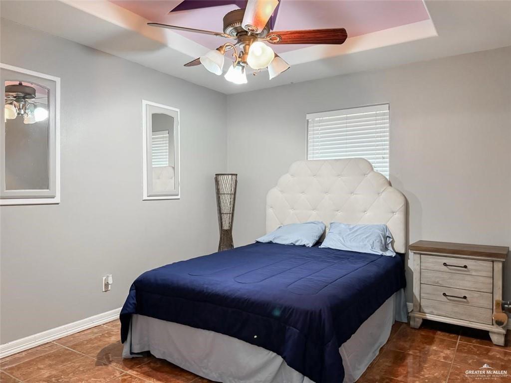 120 South Retama Lane Weslaco, TX 78596 - Photo 9 of 19 a spacious bedroom with a bed and a chandelier