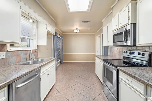 a kitchen with stainless steel appliances granite countertop a sink stove and cabinets