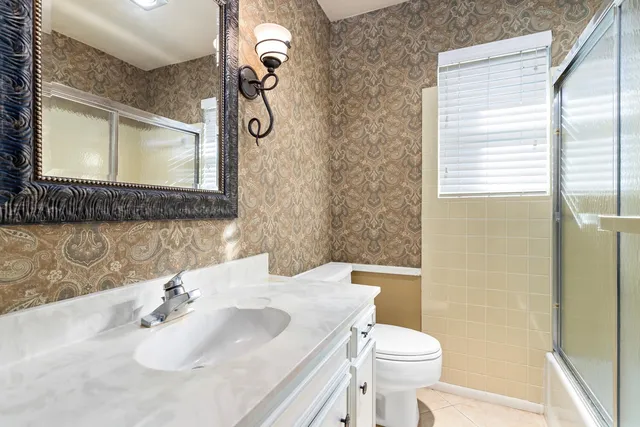 a bathroom with a sink a toilet and mirror