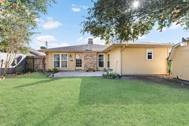 a backyard of a house with table and chairs