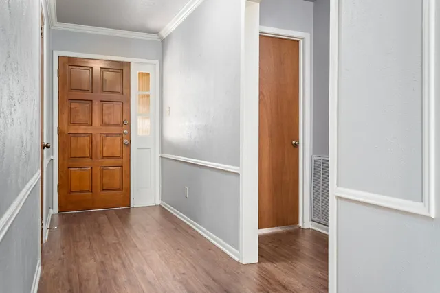a view of empty room with wooden floor