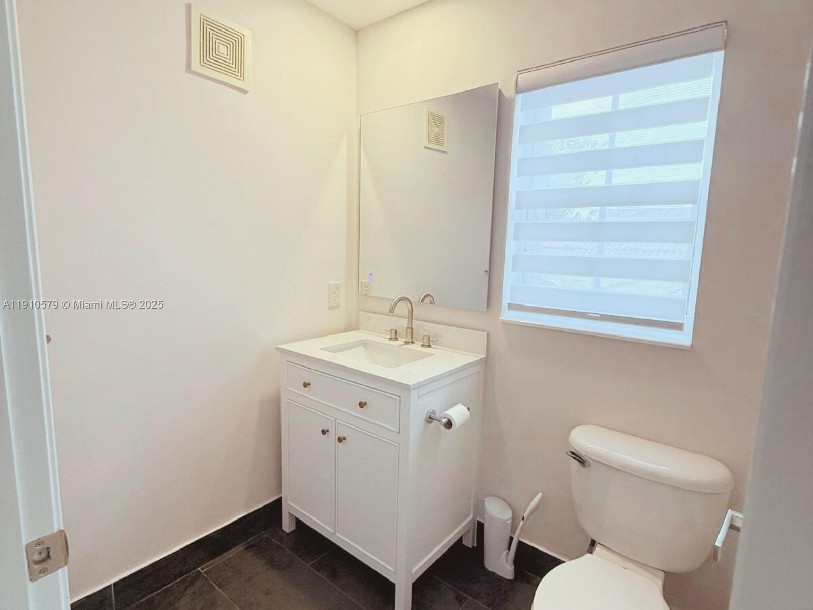 18746 Southwest 27th Court Miramar, FL 33029 - Photo 19 of 35 a bathroom with a toilet sink and mirror