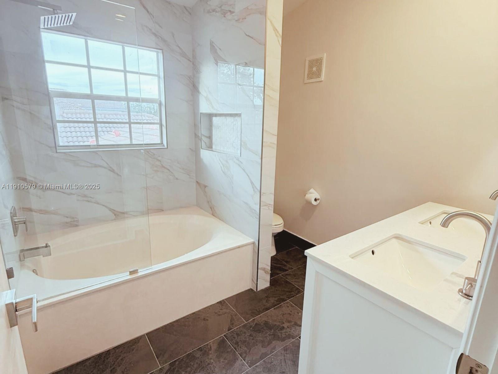 18746 Southwest 27th Court Miramar, FL 33029 - Photo 20 of 35 a bathroom with a bathtub and window