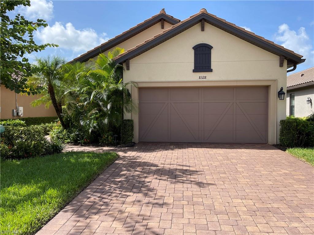 8328 Lucello Terrace North Naples, FL 34114 - Photo 2 of 22 a front view of a house with a yard