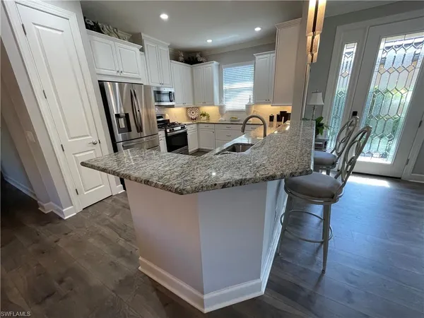 a kitchen with stainless steel appliances granite countertop a sink a refrigerator and a stove