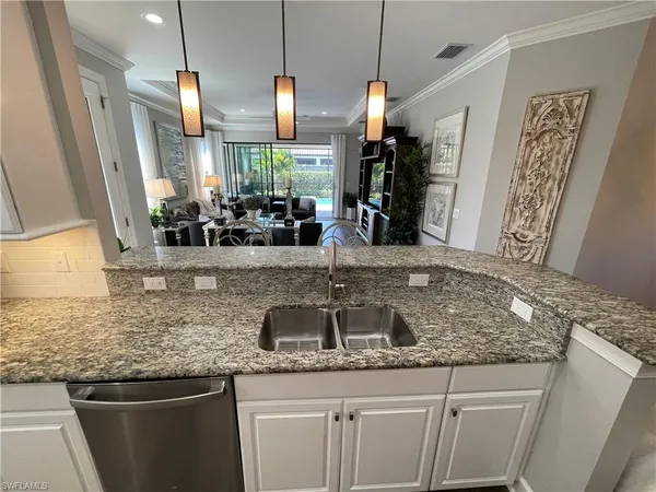 a kitchen with stainless steel appliances granite countertop a sink and a wooden floor