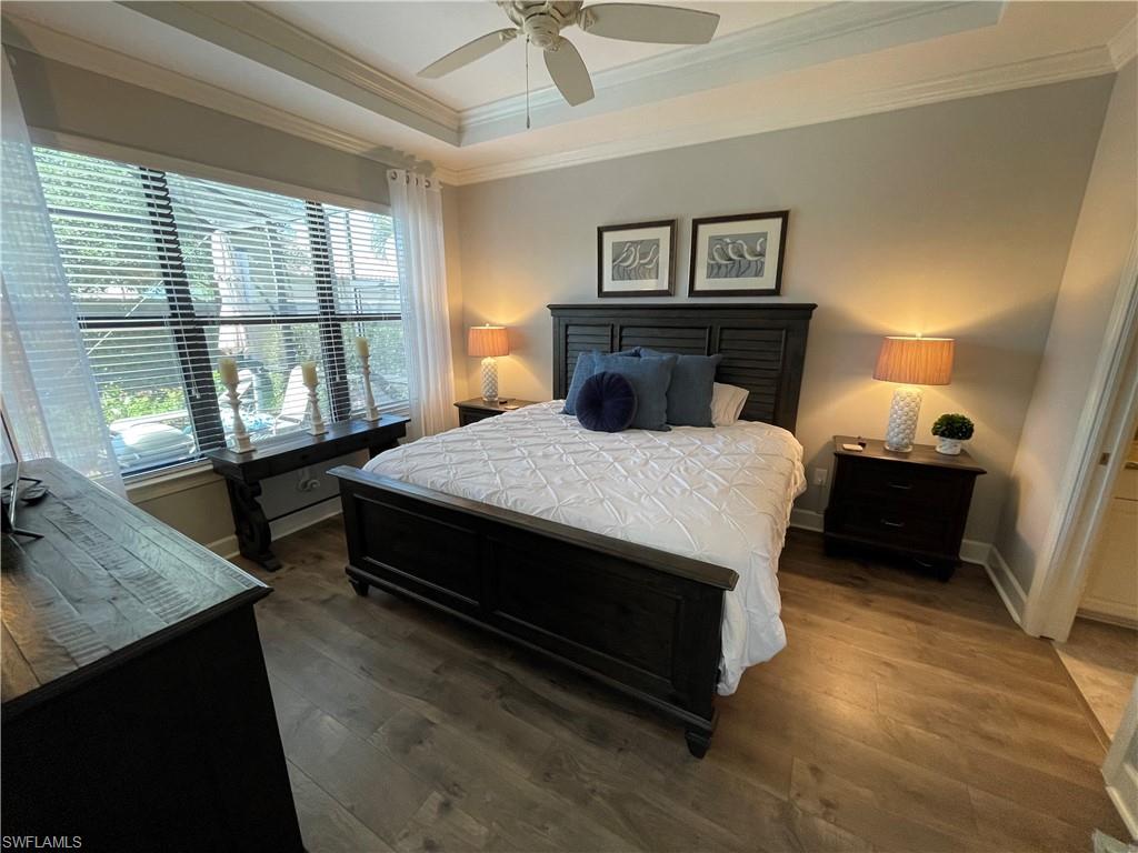 8328 Lucello Terrace North Naples, FL 34114 - Photo 10 of 22 a spacious bedroom with a bed a dresser and a chandelier