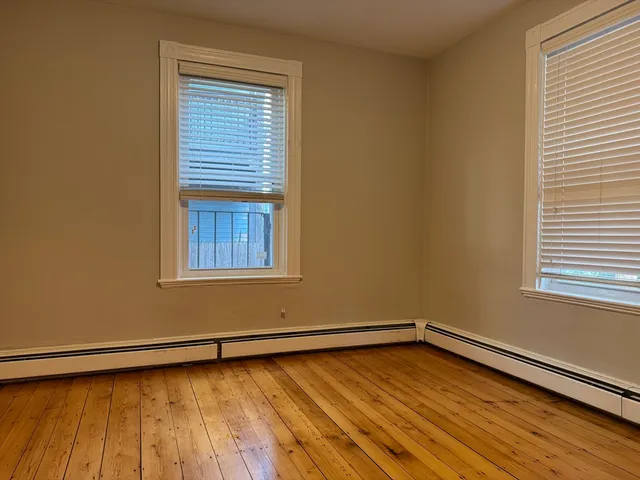 a view of a room with wooden floor and a window