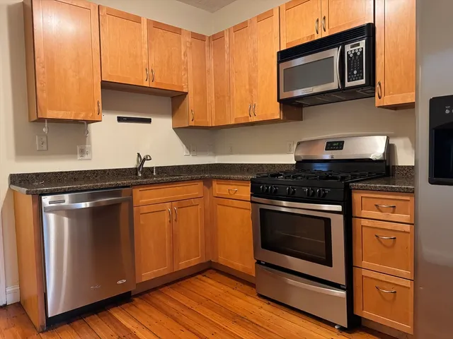a kitchen with stainless steel appliances granite countertop a stove and a microwave