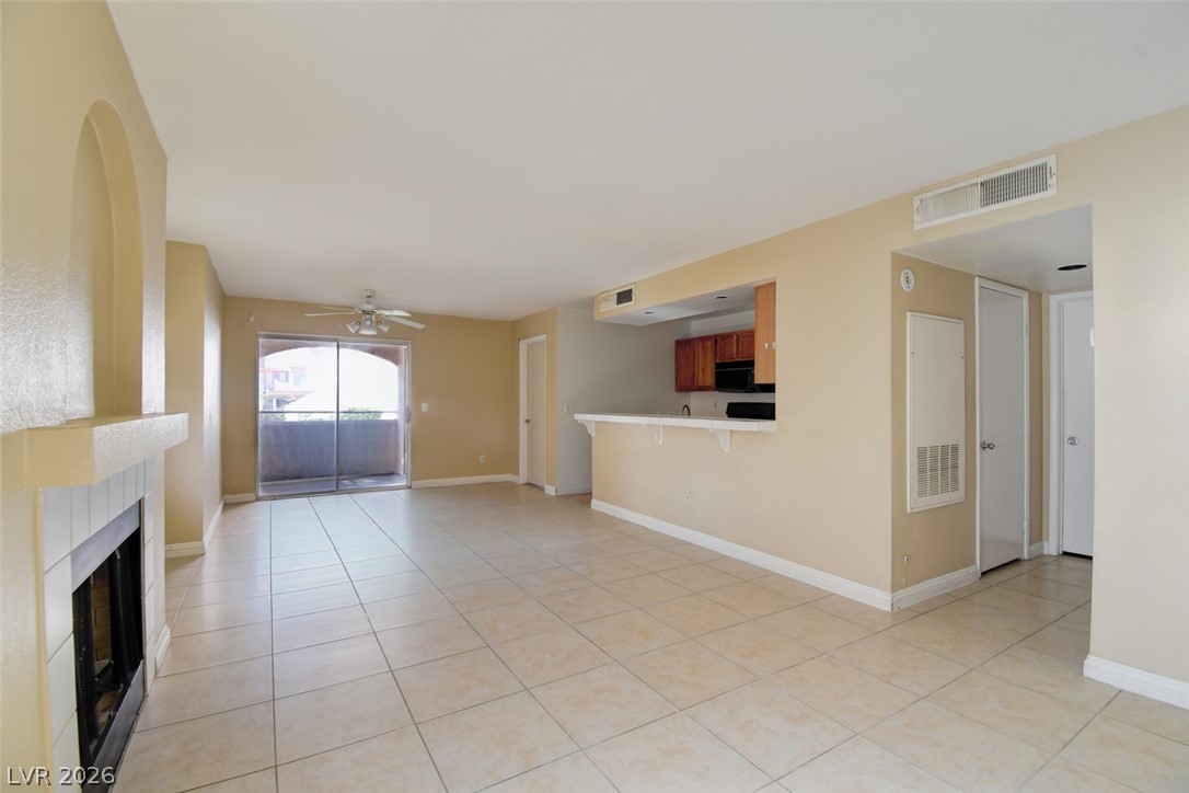 7570 West Flamingo Road, Unit 119 Las Vegas, NV 89147 - Photo 4 of 15 A fireplace warms this open-concept living space with convenient balcony access.