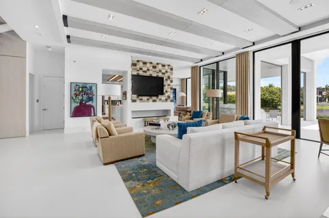 a living room with furniture a flat screen tv and a large window