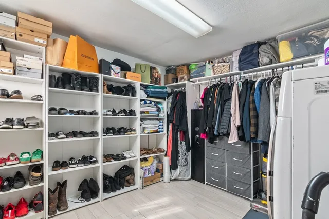 a view of walk in closet with clothes and shoes