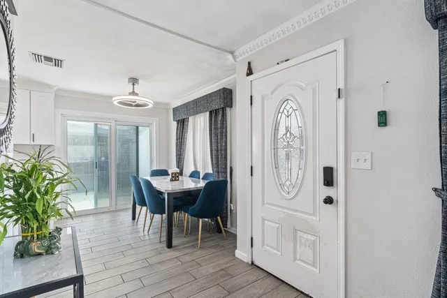a view of a hallway with dining room and wooden floor
