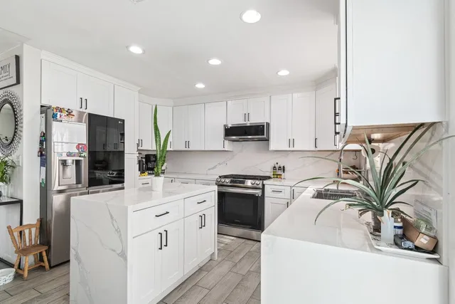 a kitchen with stainless steel appliances a refrigerator sink and cabinets