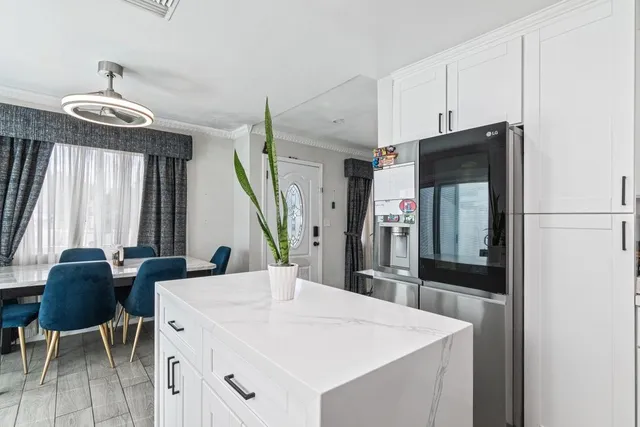 a kitchen with stainless steel appliances kitchen island granite countertop a table and chairs