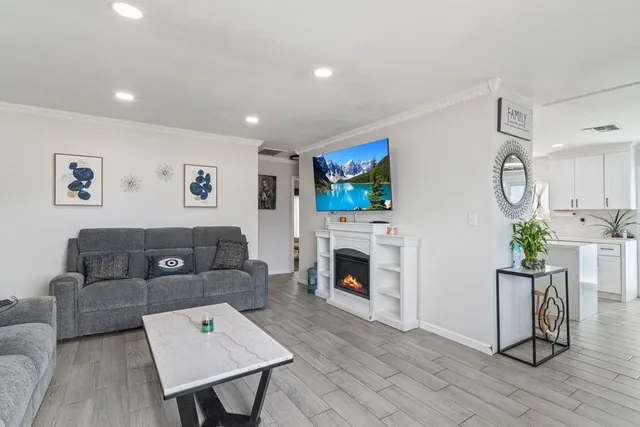a living room with furniture a flat screen tv and a fireplace