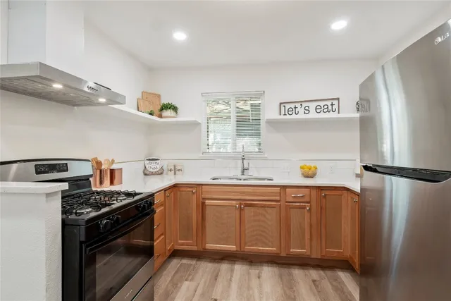 a kitchen with stainless steel appliances a sink stove and refrigerator