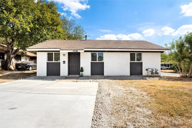 a white house that has a tree in front of it