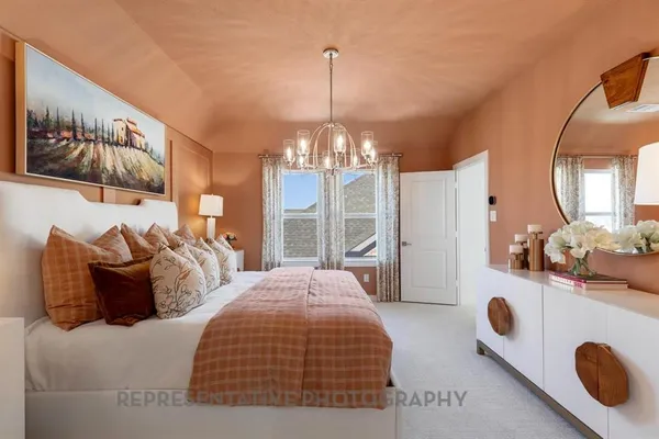 a bedroom with a bed and a chandelier