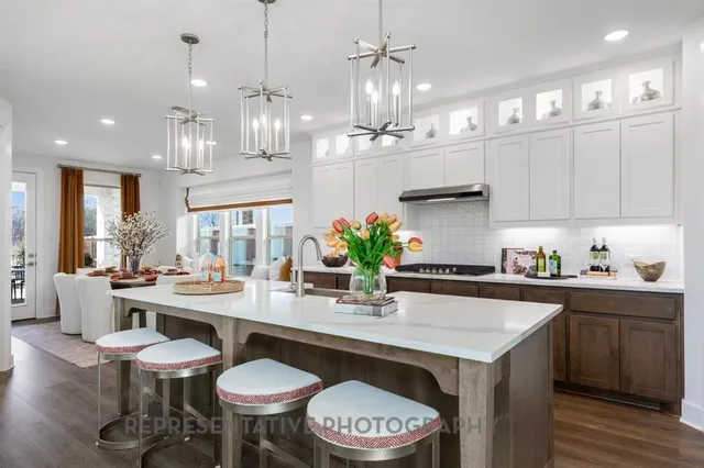 a kitchen with stainless steel appliances a table and chairs in it