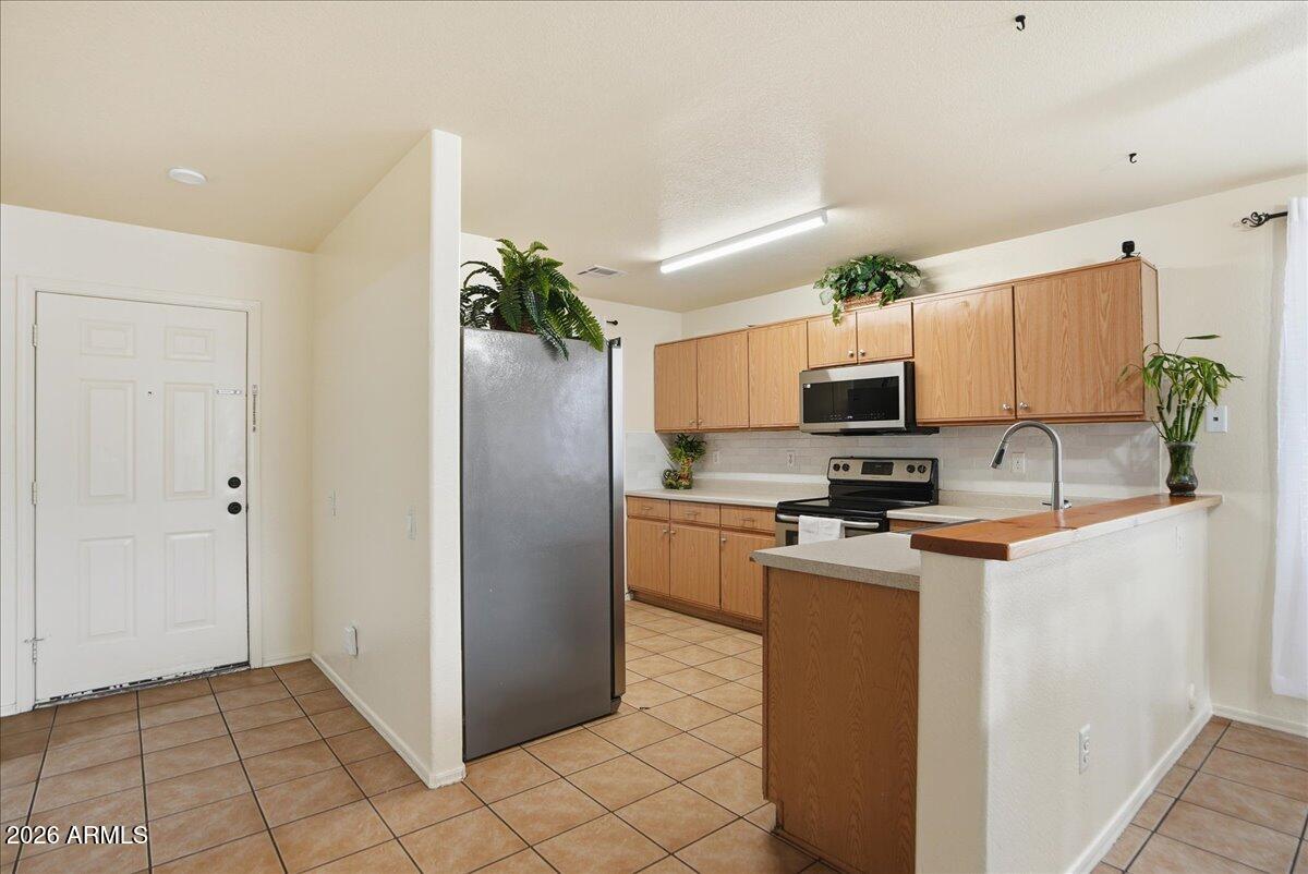 1825 West Renaissance Avenue Apache Junction, AZ 85120 - Photo 10 of 23 a kitchen with stainless steel appliances granite countertop a refrigerator a stove top oven a sink and dishwasher