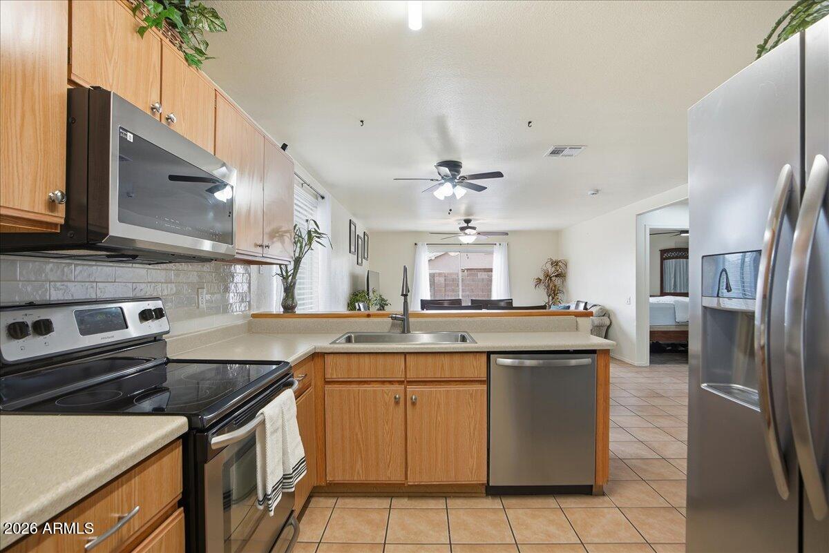 1825 West Renaissance Avenue Apache Junction, AZ 85120 - Photo 11 of 23 a kitchen with stainless steel appliances granite countertop a sink stove and refrigerator