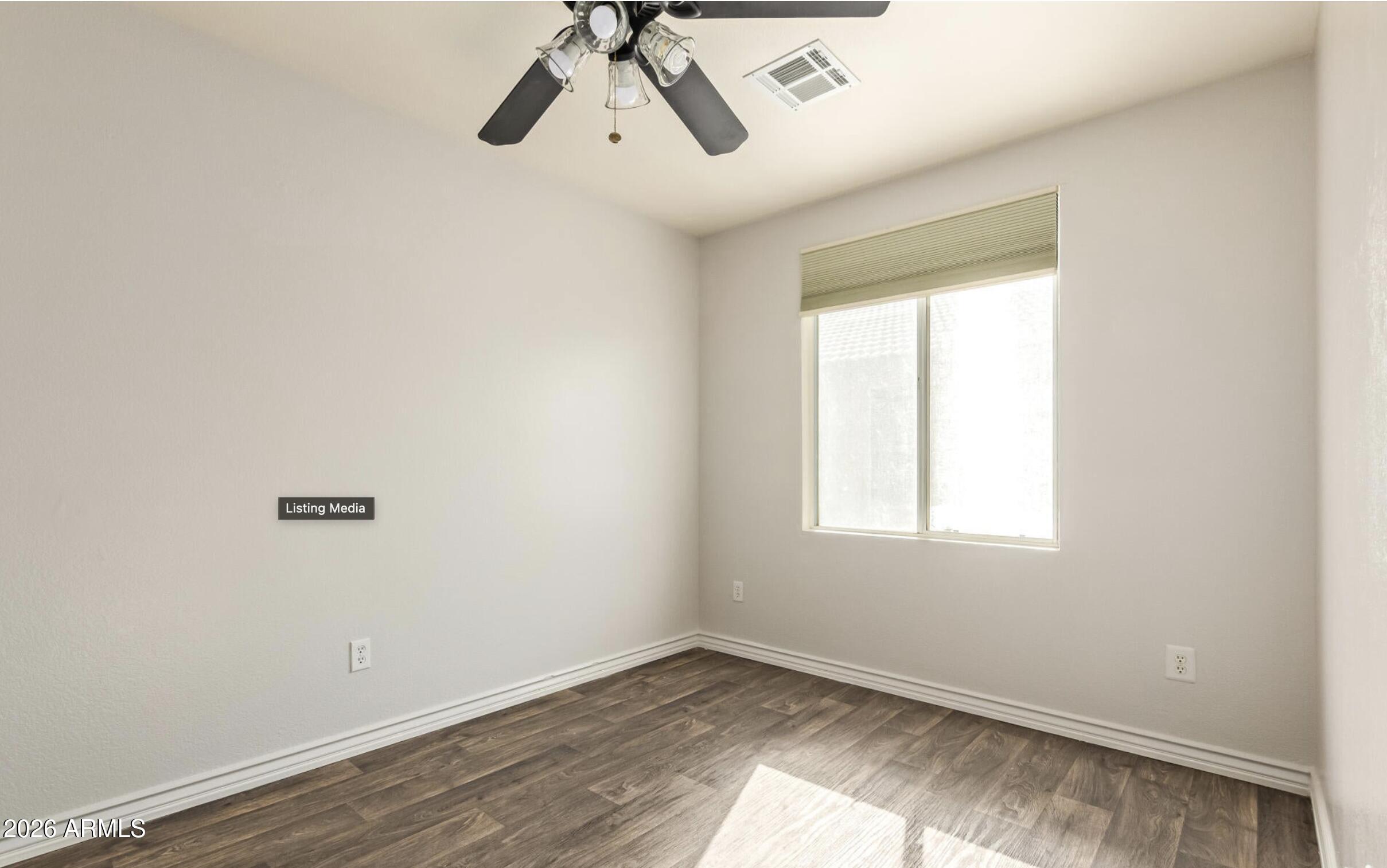 1825 West Renaissance Avenue Apache Junction, AZ 85120 - Photo 18 of 23 an empty room with a window and a ceiling fan