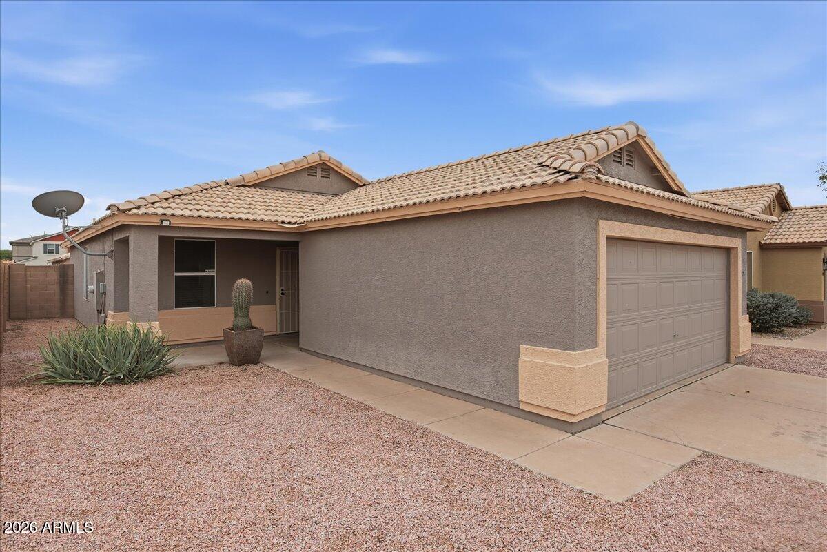 1825 West Renaissance Avenue Apache Junction, AZ 85120 - Photo 2 of 23 a front view of a house with a garage