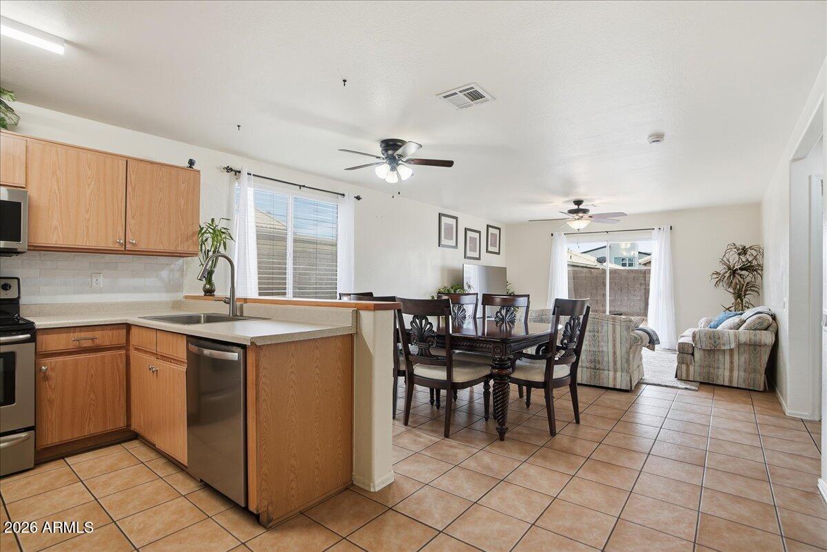 1825 West Renaissance Avenue Apache Junction, AZ 85120 - Photo 9 of 23 a kitchen with stainless steel appliances granite countertop a table and chairs in it