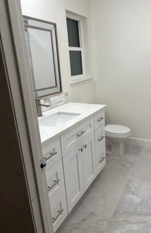 a bathroom with a toilet sink and a mirror