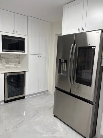 a metallic refrigerator freezer sitting in a kitchen