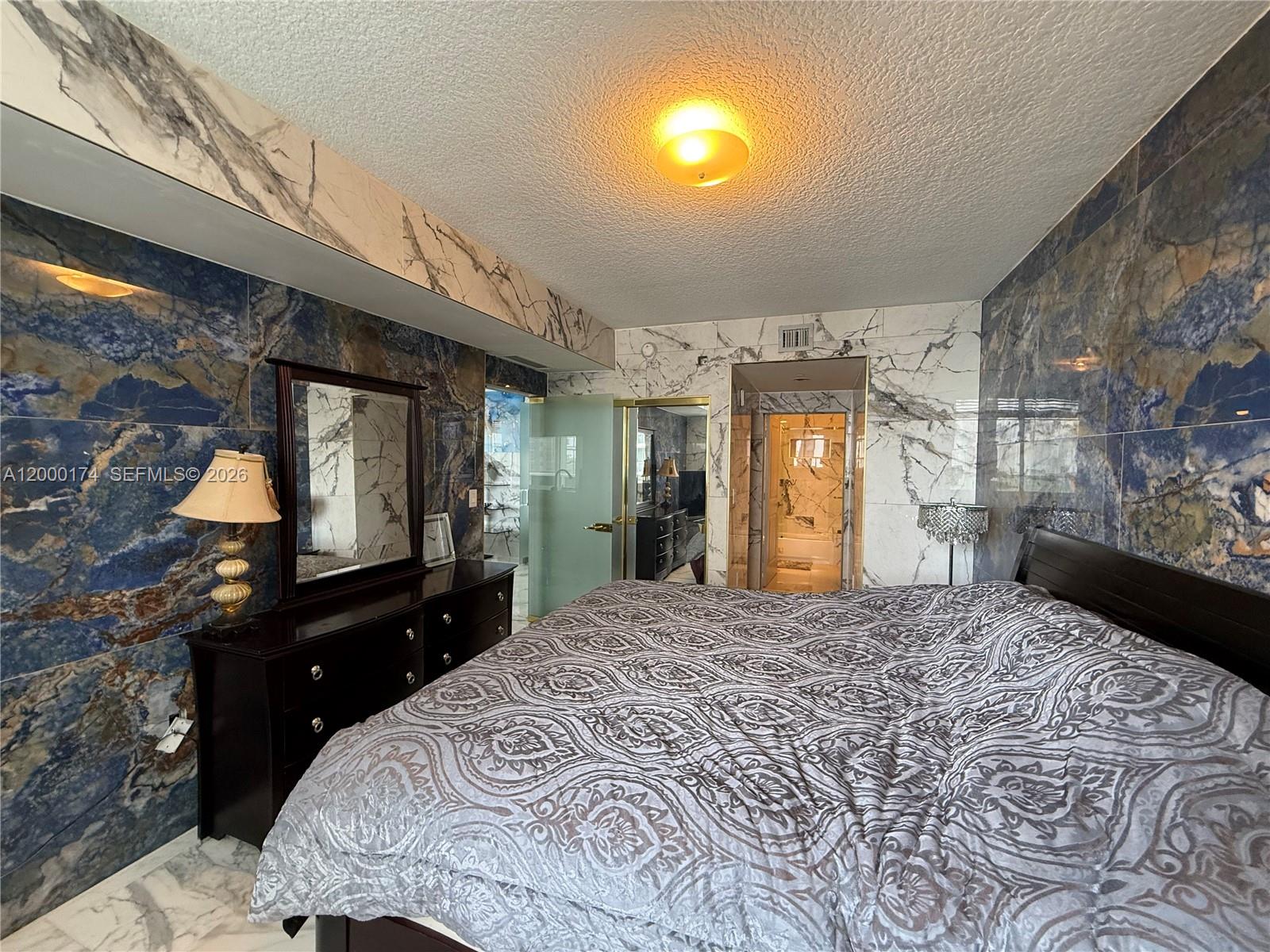 601 Northeast 23rd Street, Unit 903 Miami, FL 33137 - Photo 17 of 61 a bedroom with a bed and a television on desk
