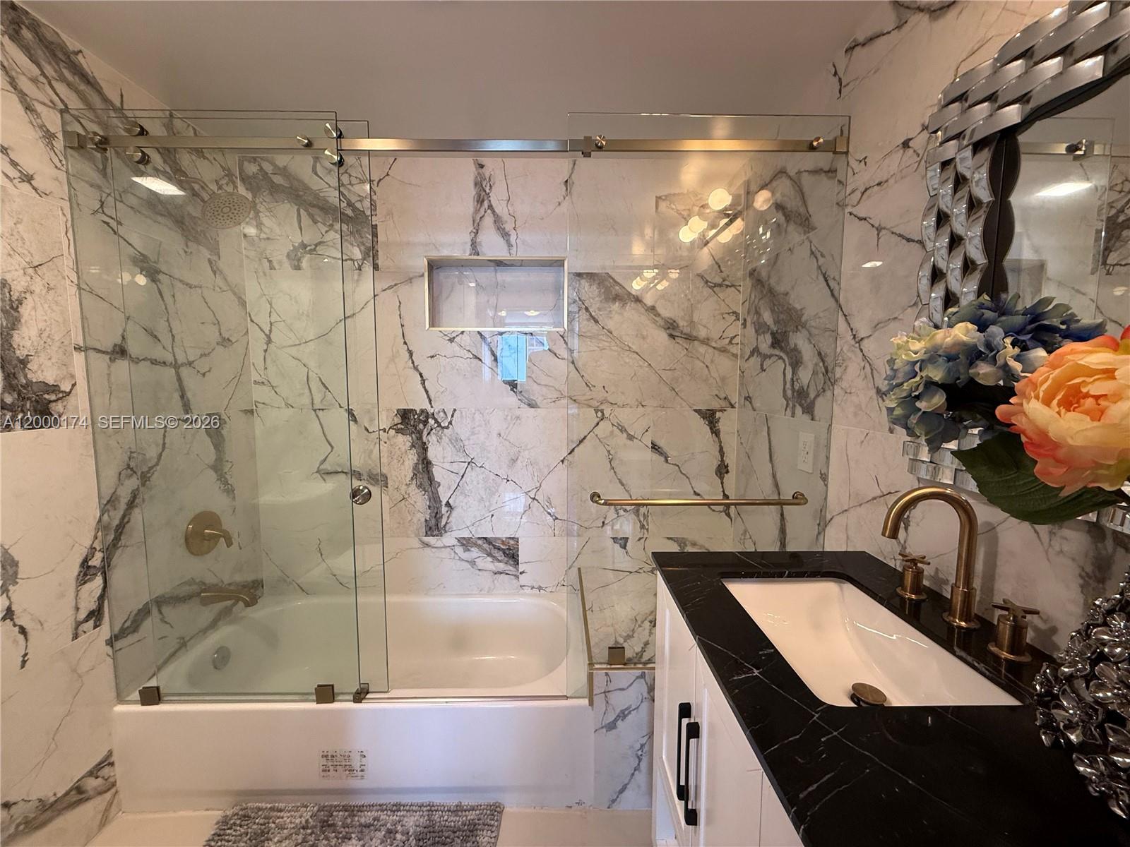 601 Northeast 23rd Street, Unit 903 Miami, FL 33137 - Photo 22 of 61 a bathroom with a granite countertop shower a sink and a mirror