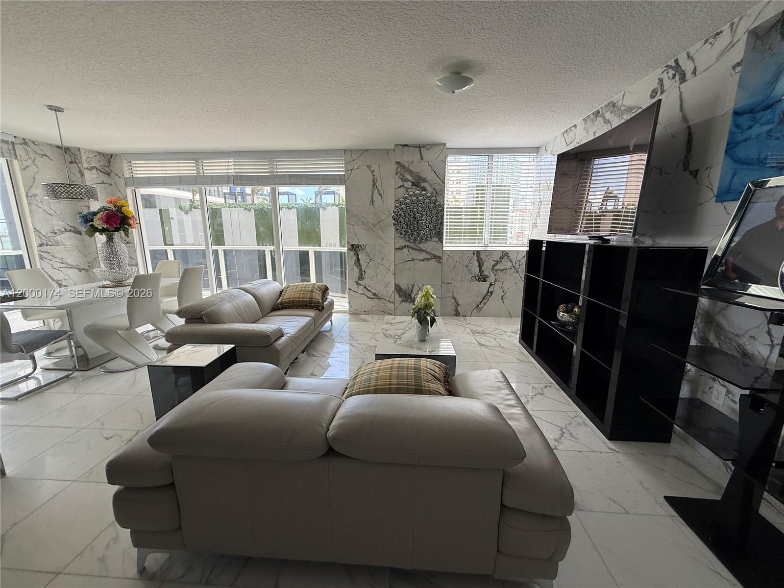 601 Northeast 23rd Street, Unit 903 Miami, FL 33137 - Photo 6 of 61 a living room with furniture and a flat screen tv