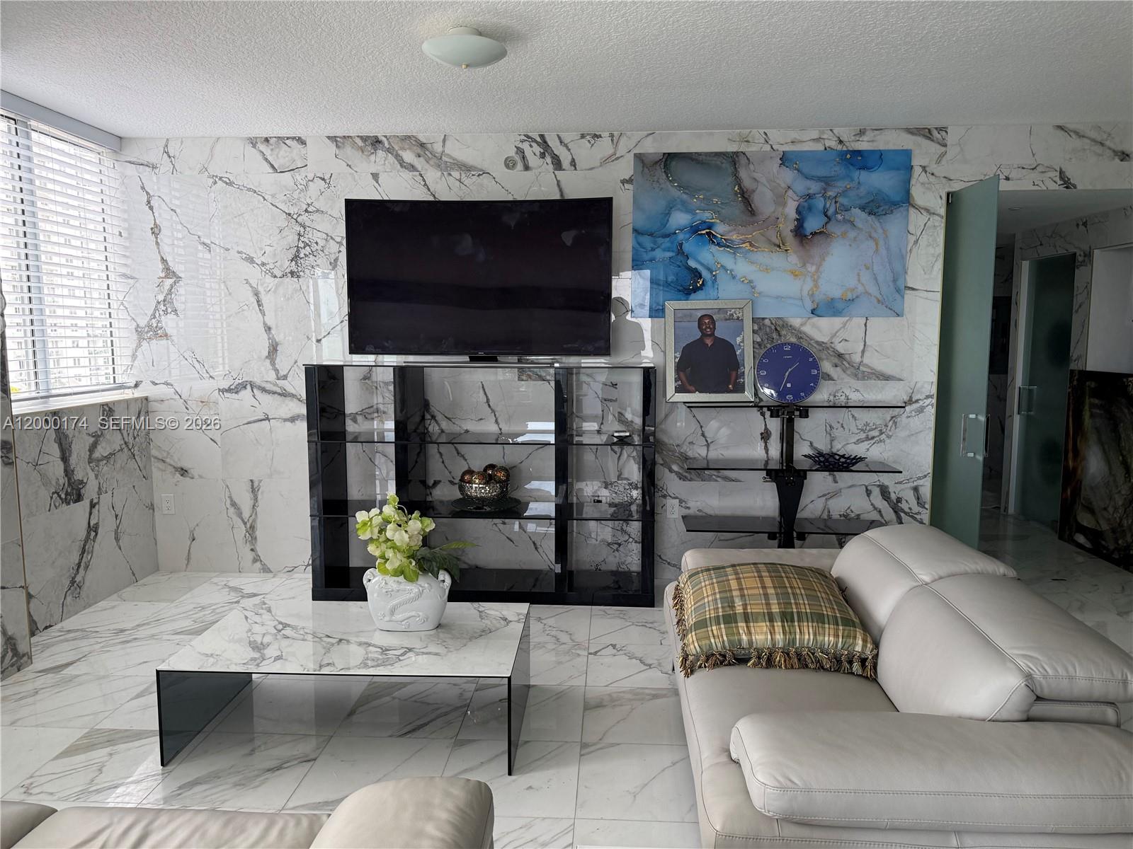 601 Northeast 23rd Street, Unit 903 Miami, FL 33137 - Photo 10 of 61 a living room with furniture a flat screen tv and a fireplace