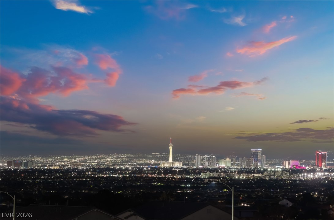 6432 Spring Jog Street Las Vegas, NV 89166 - Photo 59 of 61 City lights stretch across the horizon, painting a dynamic urban view beneath a twilight sky.