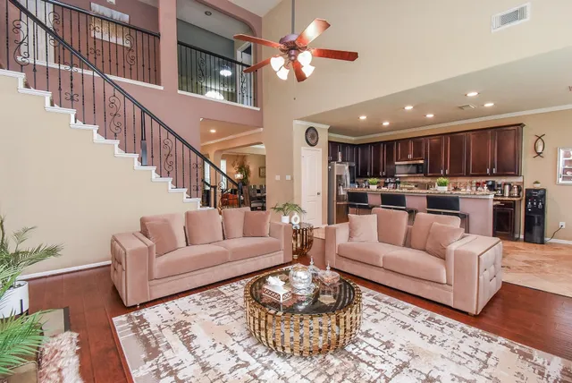 a living room with furniture kitchen and a wooden floor