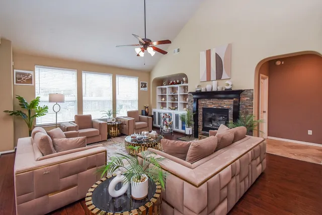 a living room with furniture a fireplace and a large window