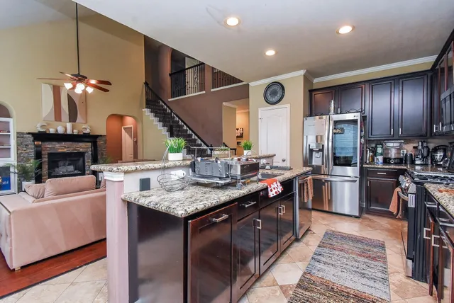 a kitchen with stainless steel appliances granite countertop a sink a stove and a refrigerator