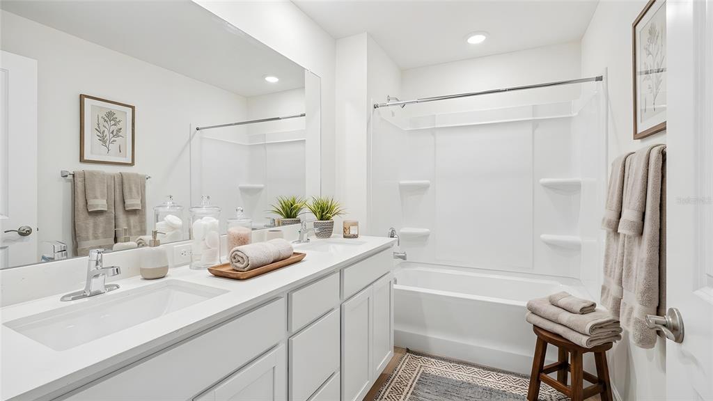 4706 Kona Circle Spring Hill, FL 34608 - Photo 6 of 18 a bathroom with a granite countertop sink mirror and a shower