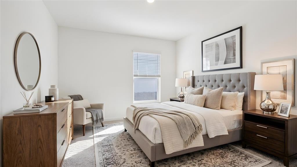 4706 Kona Circle Spring Hill, FL 34608 - Photo 7 of 18 a bedroom with a bed a mirror and a lamp on dresser