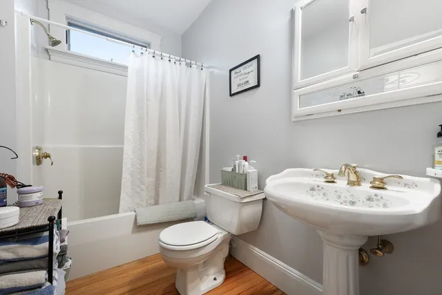 a bathroom with a sink a toilet and shower curtain