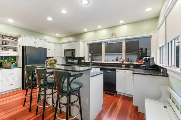 a kitchen with stainless steel appliances kitchen island granite countertop a sink and cabinets