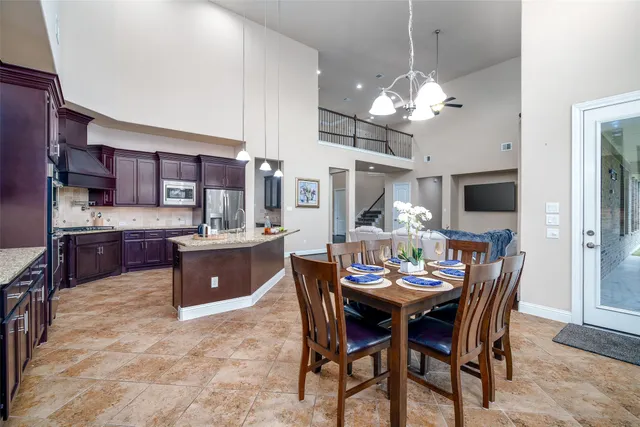 a view of a dining room with furniture a kitchen and chandelier
